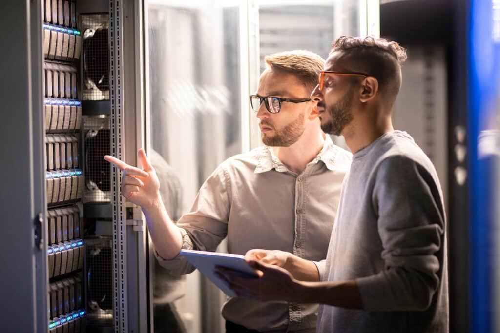 2 male IT professionals solving network server problems