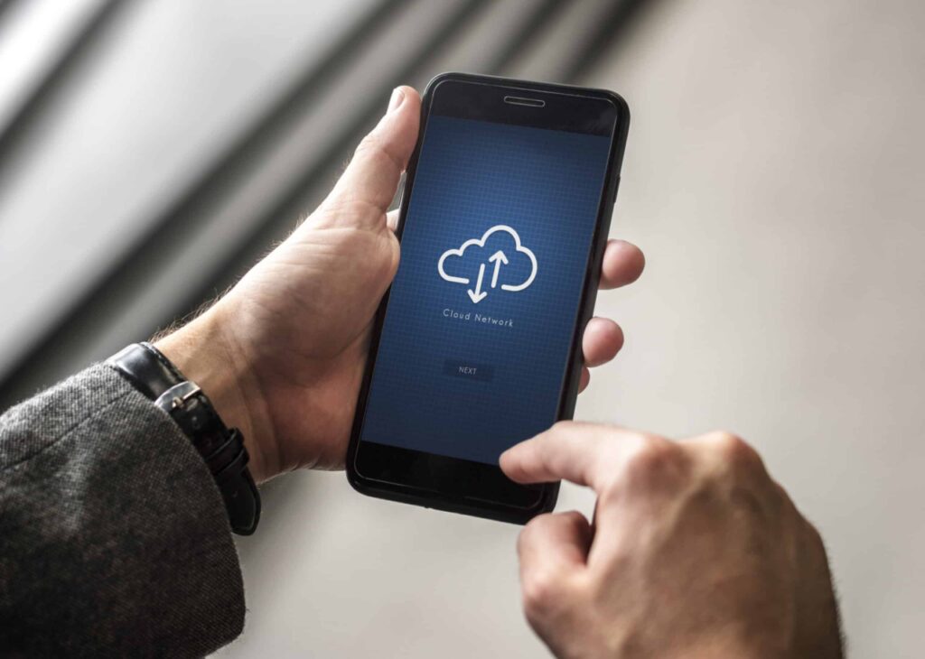 cloud adoption concept with cloud icon showing on man's smartphone