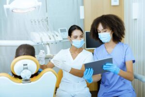 dentists use ipad and other dental technology solutions while treating patient