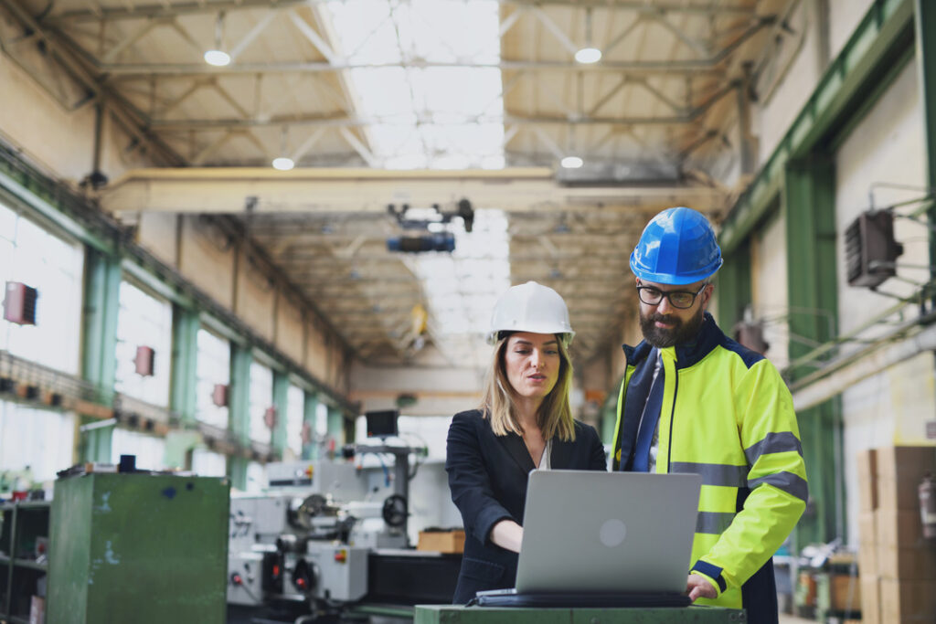 A manufacturing team discusses their IT services while looking at a laptop