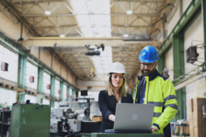 A manufacturing team discusses their IT services while looking at a laptop